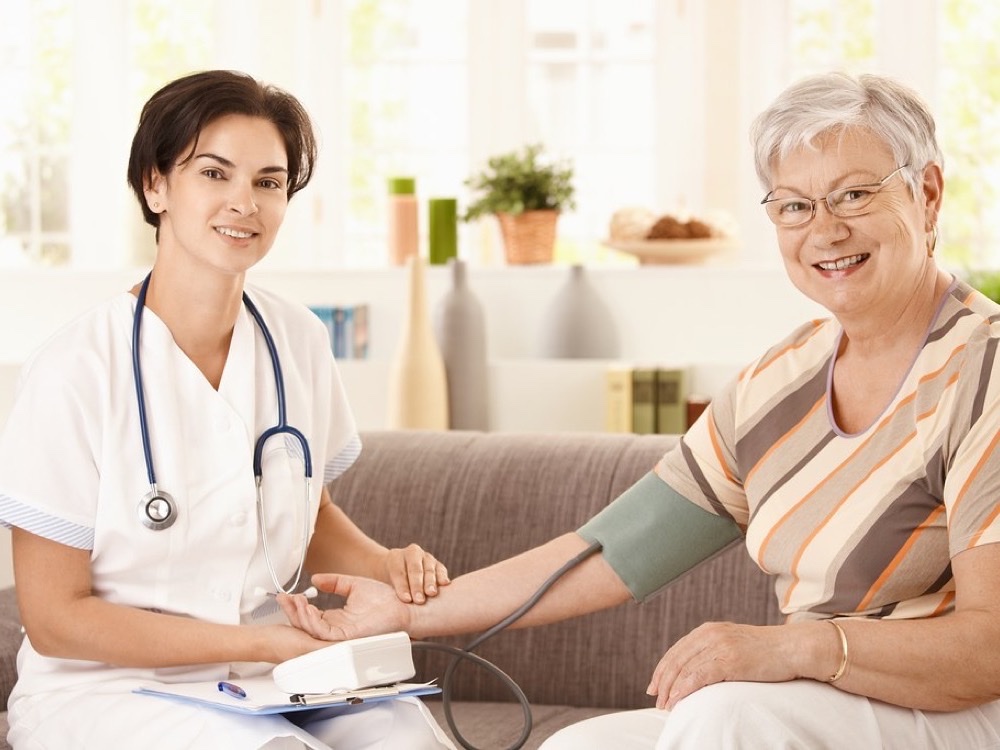 A calm home care conversation between a carer and an older person